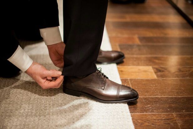 A tailor adjusts the hem and pant length of a wedding suit
