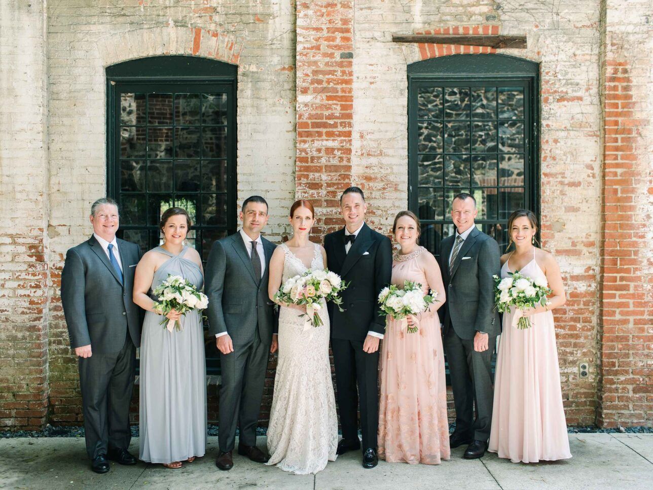 Wedding party with complementing outfits for groomsmen and bridesmaids