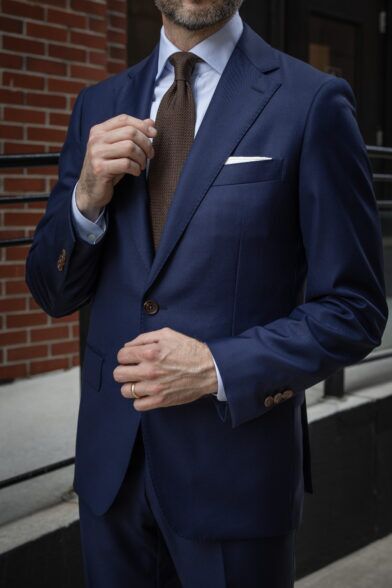 A blue shirt and brown tie is a subtle approach to styling a royal blue suit.