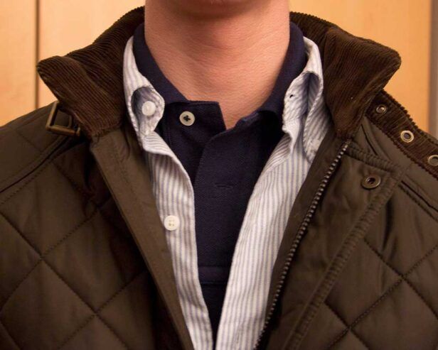 A polo shirt layered under an Oxford cloth button down