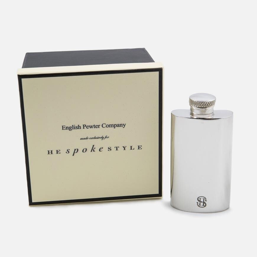 Polished pewter hip flask with monogram and screw cap, shown beside its cream and black gift box