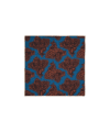 Blue paisley pocket square with rust and brown print and hand-rolled tan edge, flat lay