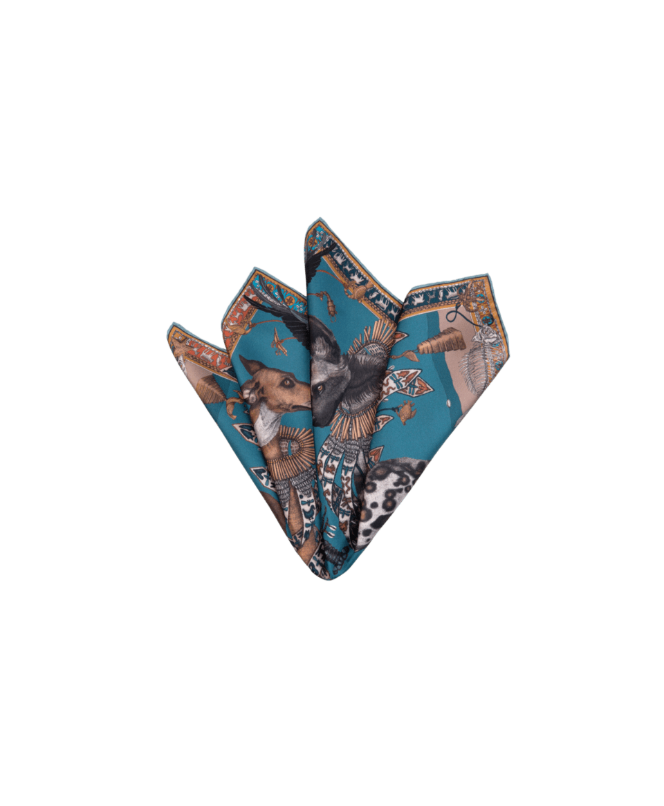 Teal silk twill pocket square with Egyptian-style dog and jackal print, folded in multiple points