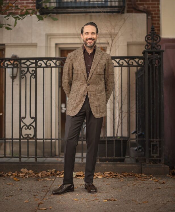 Brown glen plaid wool sport coat with burgundy knit polo, dark brown trousers and loafers, worn by a model