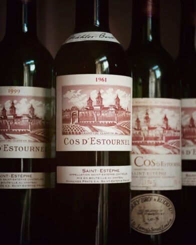 Bordeaux wine bottles with Cos d'Estournel Saint-Estèphe labels, 1961 vintage in focus, close-up still life