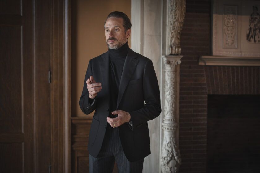 Black basketweave wool sport coat with black turtleneck and grey pinstripe trousers, worn by a model