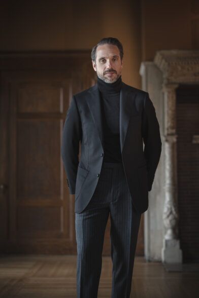 Black basketweave wool sport coat with black turtleneck and charcoal chalk stripe trousers, worn by a model