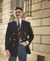 Navy double-breasted blazer with gold buttons, striped tie, white shirt and jeans, worn by a model on a city street