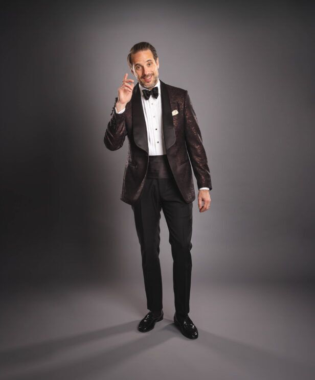 Brown jacquard shawl collar dinner jacket with pique stud shirt, black bow tie and cummerbund