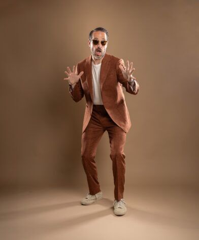 Terracotta slub linen suit with cream t-shirt and off-white sneakers, worn by a model