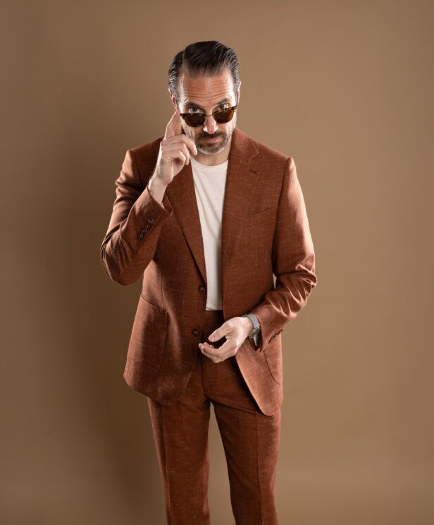 Terracotta linen-blend suit with notch lapels and cream t-shirt, worn by a model