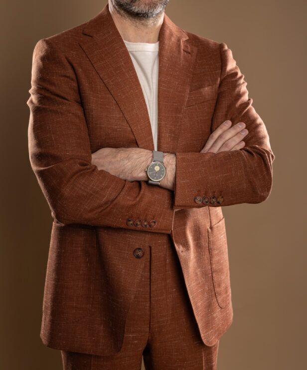 Terra cotta linen-blend suit with peak lapels and cream tee, worn by a model, cropped at the chest