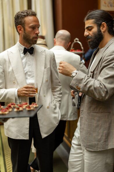 Cream double-breasted dinner jacket with black bow tie and pleated shirt, worn at a cocktail event