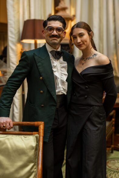 Dark green double-breasted dinner jacket with gold buttons, ruffled shirt and black bow tie, at an evening event