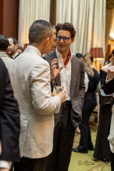 Brown linen sport coat with white shirt and red neckerchief, worn at a cocktail reception