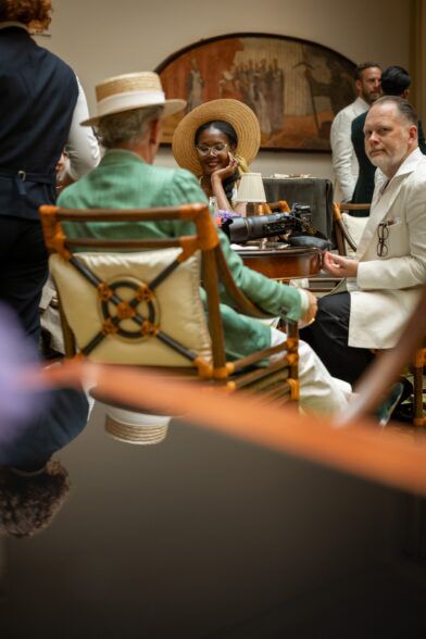 Green linen sport coat and cream linen jacket with pocket square, worn by guests at a hotel cocktail event