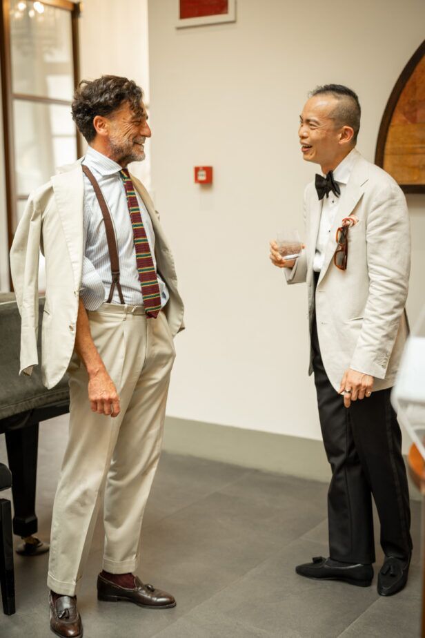 Cream cotton sport coats with striped knit tie and black bow tie, worn by two men at a styled cocktail event