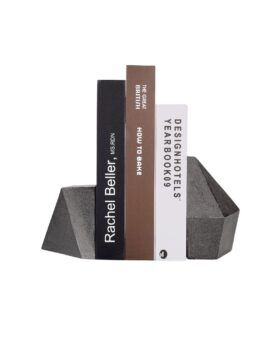 Pair of faceted dark grey cast iron bookends holding three books upright