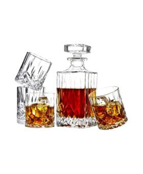 Cut crystal whiskey decanter with four matching tumblers, filled with amber spirit
