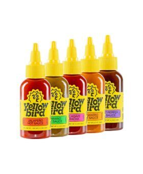 Five Yellowbird hot sauce bottles in jalapeno, serrano, sriracha, habanero and ghost pepper, product set
