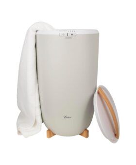 Zadro cream hot towel warmer on a bamboo stand with a white towel draped over the rim