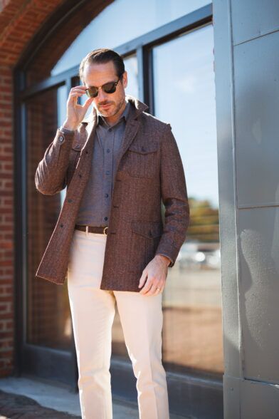 Brown flannel safari jacket with a grey polo and cream trousers, worn by a model