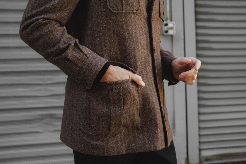 Brown flannel safari jacket, a close-up of the flap pocket with a hand tucked inside