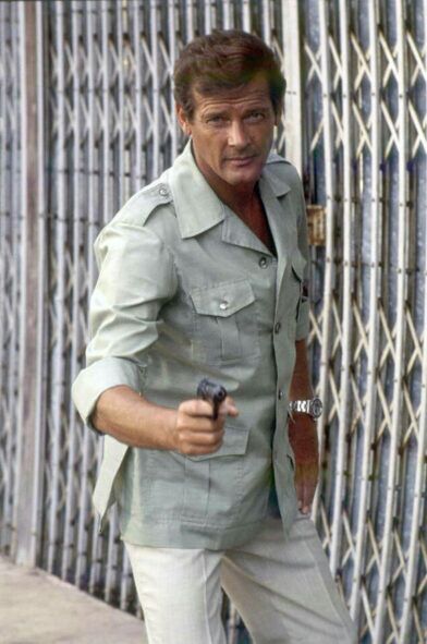 Sage green safari jacket with patch pockets and rolled sleeves, worn on a street