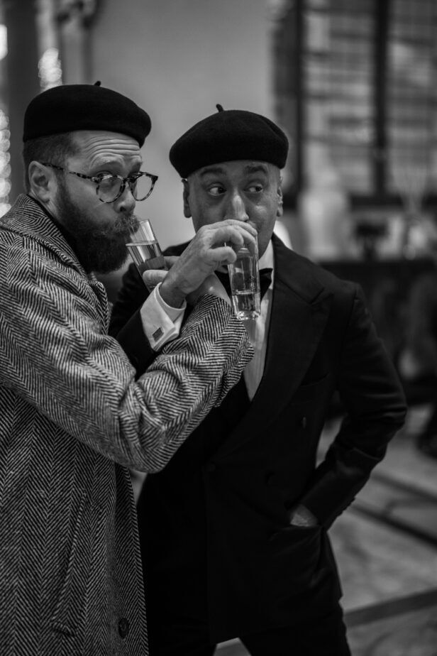 Grey herringbone overcoat and a black dinner jacket, worn by two guests in berets