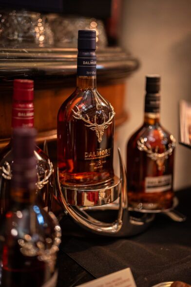 Dalmore 18 Year whisky bottle with a silver stag emblem, on a hotel bar stand