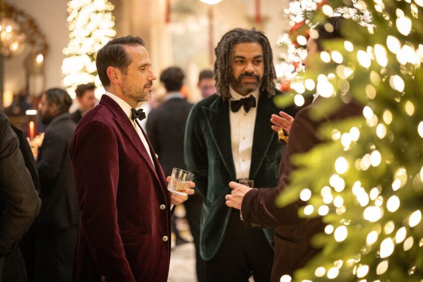 Burgundy velvet dinner jacket beside a green velvet jacket, worn by guests at a party