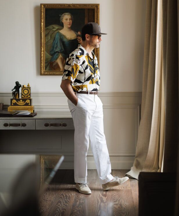 Printed camp shirt with white trousers and cream boat shoes, worn by a model in profile