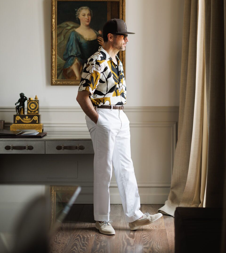 Printed camp shirt with white trousers and cream boat shoes, worn by a model in profile