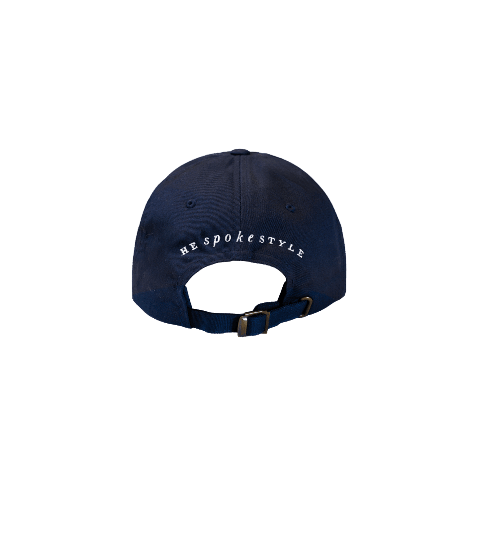 Navy cotton baseball cap with He Spoke Style embroidered in white, rear view with strap