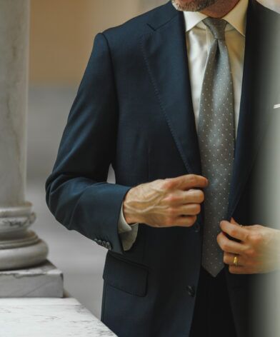Teal blue wool suit jacket with white shirt and grey dotted silk tie, worn by a model