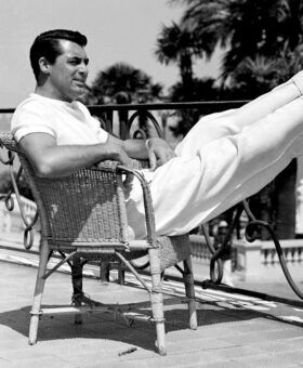 White short-sleeve tee and white wide-leg trousers with loafers, on a terrace, black and white