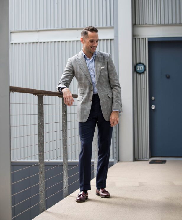 Grey windowpane sport coat with blue oxford shirt, navy trousers and burgundy tassel loafers, worn by a model