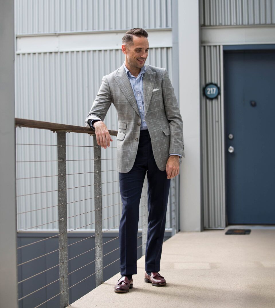 Grey windowpane sport coat with blue oxford shirt, navy trousers and burgundy tassel loafers, worn by a model