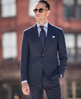 Navy hopsack suit with patch pockets, blue shirt and burgundy medallion tie, on a city street