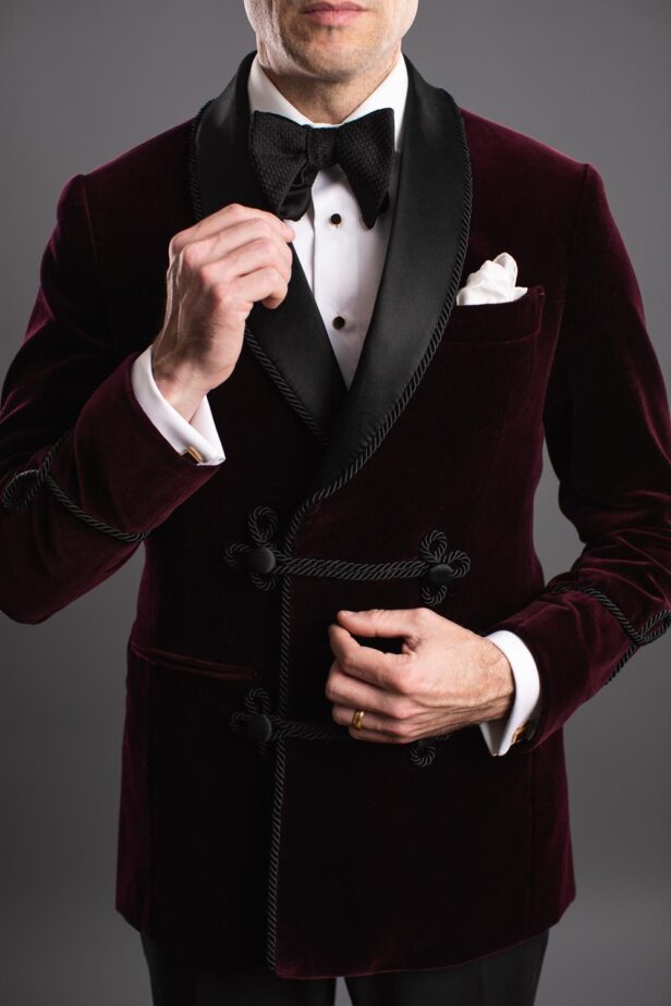 Burgundy velvet smoking jacket with black satin shawl collar, frog buttons and soutache trim