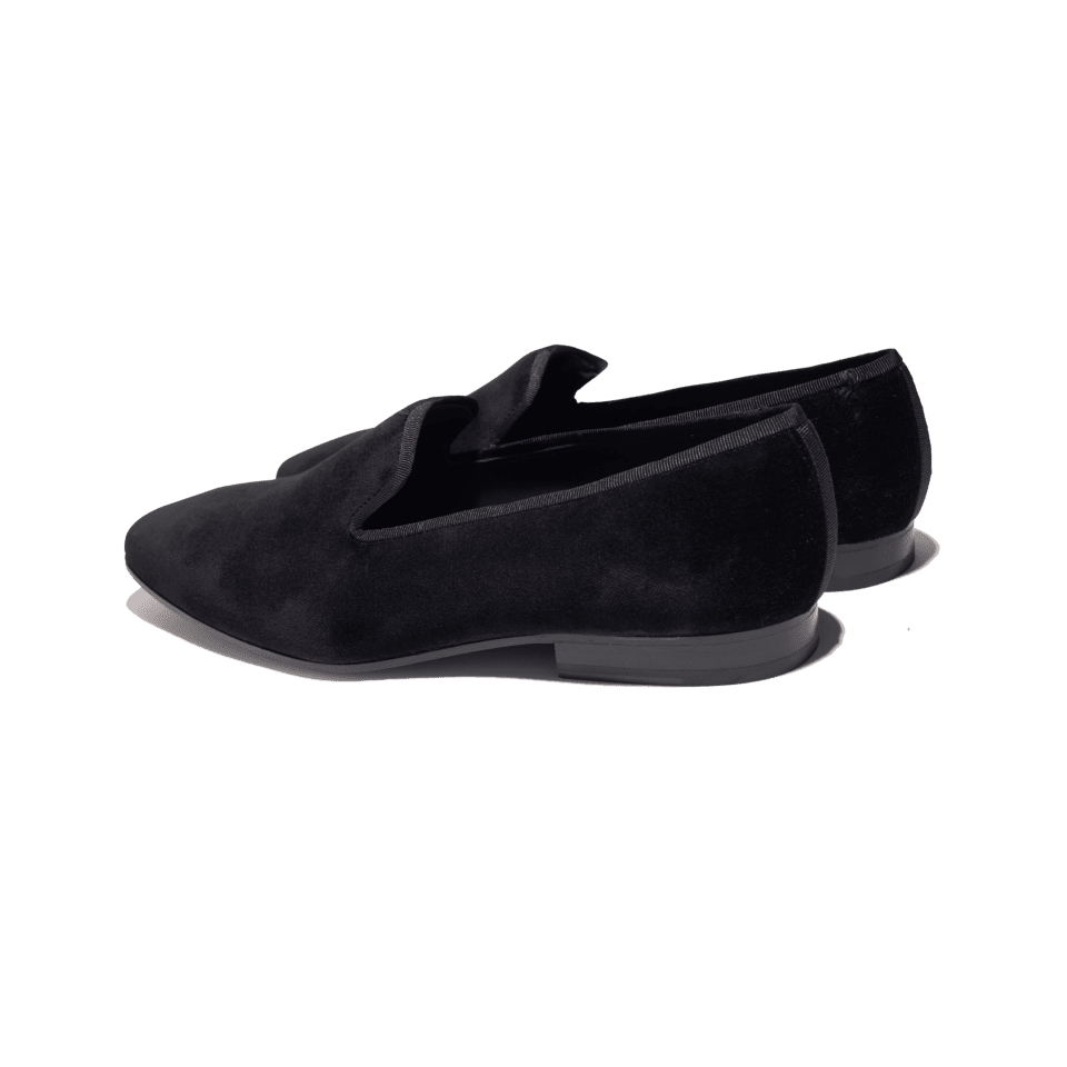 Black velvet slippers with grosgrain trim, angled rear three-quarter view of the pair