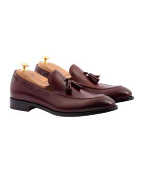Bordeaux leather tassel loafers with leather soles and cedar shoe trees, angled product view