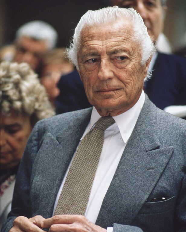 Grey flannel suit jacket with peak lapels, white shirt and tan woven wool tie, worn by a man