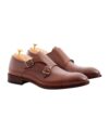 Brown leather double monk strap cap toe shoes with silver buckles and cedar shoe trees, product shot