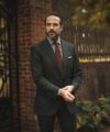 Forest green flannel suit with brown gingham shirt, brown wool tie and white pocket square, worn by a model outdoors