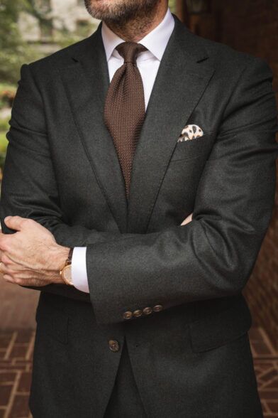 Forest green flannel suit with white shirt, brown grenadine tie and paisley pocket square, worn by a model