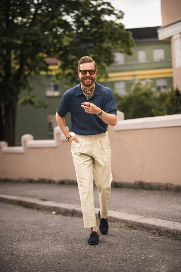 Navy cable knit polo with green silk neckerchief, cream pleated trousers and navy suede loafers, styled street scene