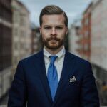 Navy hopsack suit jacket with cream button-down shirt, blue patterned tie and printed pocket square, worn by a model
