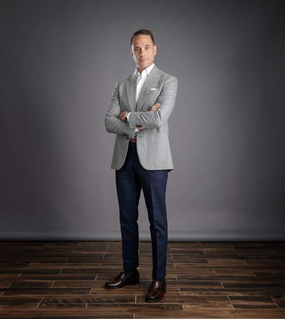 Light grey flannel sport coat with patch pockets, white shirt and navy trousers, worn by a model