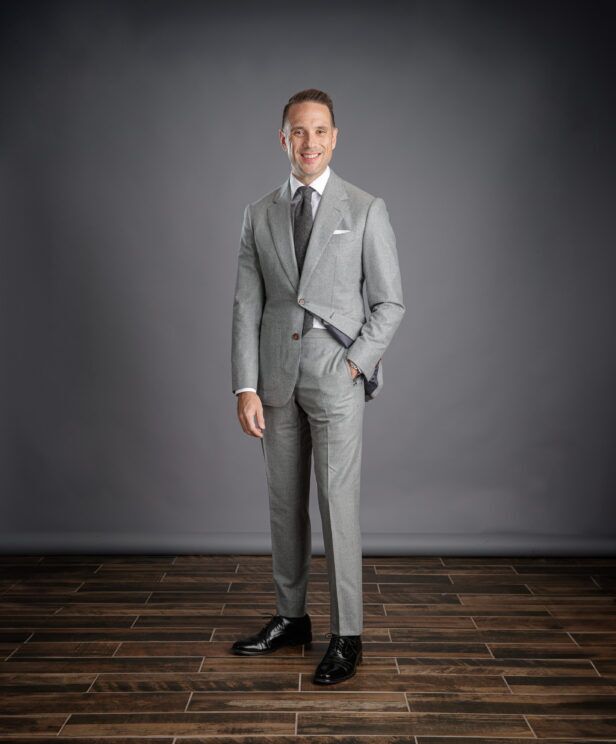 Light grey flannel suit with white shirt, grey tie, white pocket square and black oxfords, worn by a model